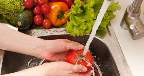 Rửa rau dưới vòi nước để đảm bảo an toàn 